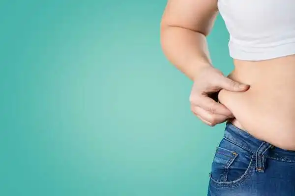Image of woman pinching her love handles to show weight gain Coventry